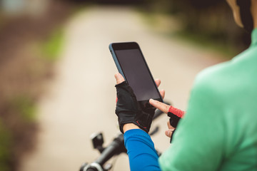 Cyclist use smartphone for navigation when riding mountain bike on forest trail