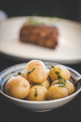 Close up images of a side of boiled potatoes being served in a gourmet restaurant