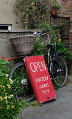 Fototapeta na wymiar Pretty village shop sign attached to a Dutch bicycle with basket