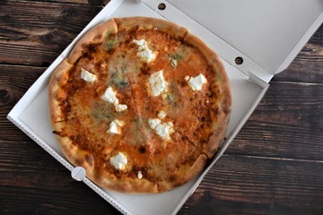 baked italian pizza in a white box