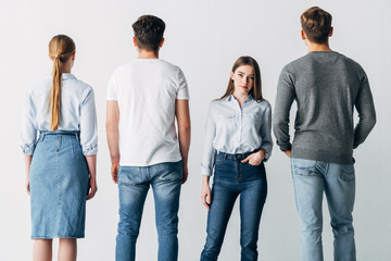 Naklejka premium Attractive employee with hand in pocket looking at camera near candidates