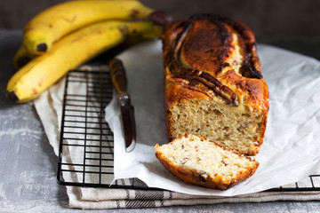 Banana muffin with candied ginger and raisins and bananas on a gray background.