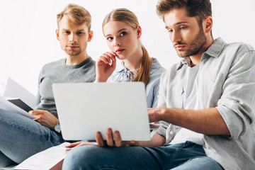 Selective focus of employees with resume looking at laptop in office