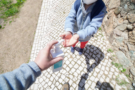 Father Using Wash Hand Sanitizer Gel Pump Dispenser Outdoors