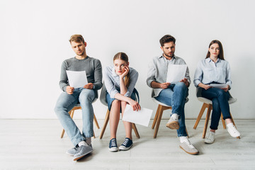 Group of employees with resume waiting for job interview in office