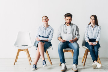 Obraz premium Attractive woman smiling at camera near employees in office