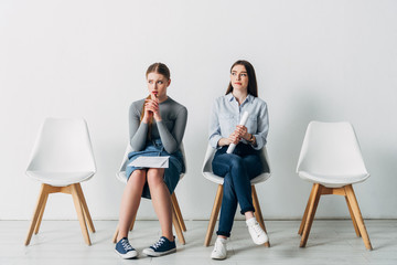 Obraz premium Thoughtful candidates with resume waiting for job interview in office