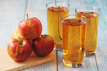 Glasses with apple juice and ripe apples