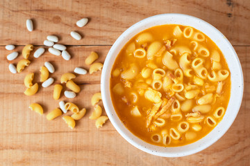 A plate of pasta and beans from above. On the side: raw beans and pasta.