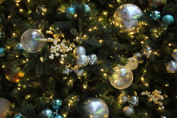 Christmas decorations on Christmas tree with fairy lights and clear and glitter baubles