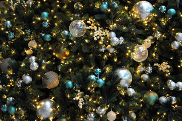 Christmas decorations on Christmas tree with fairy lights and clear and glitter baubles