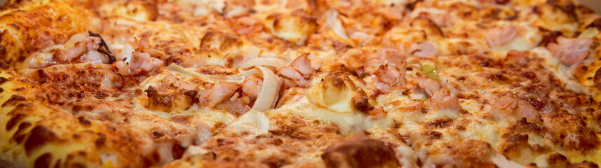 A closeup of delicious BBQ homemade pizza with double cheese, chicken, onion and bacon. Intense colors. Food background concept. With place for text