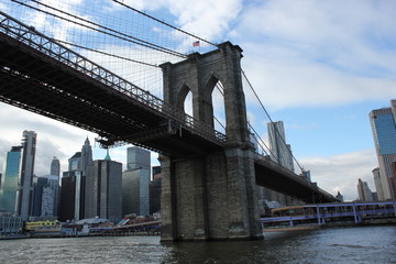 Obraz premium New york, USA - 20.12.2019: Brooklyn bridge in New York, Manhattan skyscrapers skyline behind across Hudson river at end of day New York, USA - stock photo