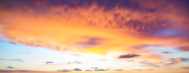 Vivid wide view photo of cloudy sky during sunset, with magenta, cyan, orange and purple colors of the sky. Nature background