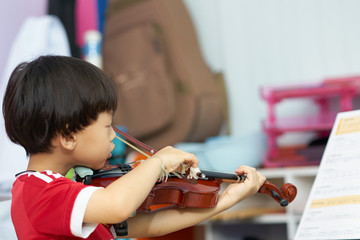 boy plays violin on blur background with note stand in covid-19 crisis quarantine time period © vach