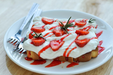 Summer dessert.  Bread with  whipped cream and strawberries in a white dish.