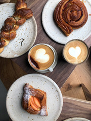 Delicious breakfast in the coffee shop with beautiful milky coffee and pastries
