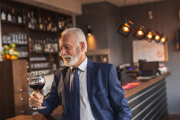 Senior businessman drinking wine in restaurant