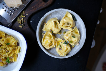 Delicious homemade tortelloni served with pistachios on the dark background