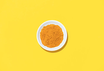 Turmeric powder in a bowl, top down view
