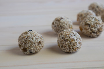 Close-up of energy balls in coconut flakes on a light background, horizontal orientation