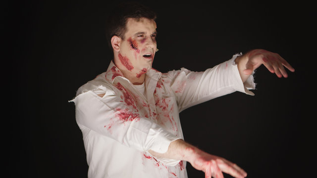 Caucasian young man dressed up like a zombie from horror movie for halloween.