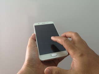 Woman hand is holding a mobile phone, Index finger is dabbing