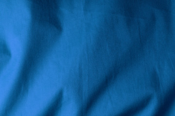 Blue fabric background, crumped backdrop with shadows