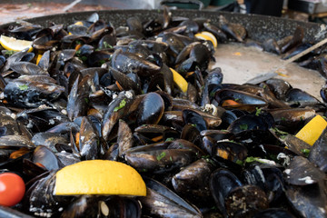 Fresh mussels in shells at steam pan. Seafood barbecue outdoors.