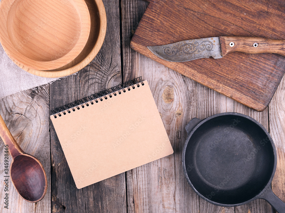 Poster empty black round frying pan with handle and spoon