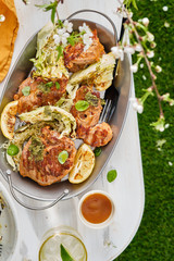 Grilled turkey steak with cabbage and herbs on the nature. Spring concept.