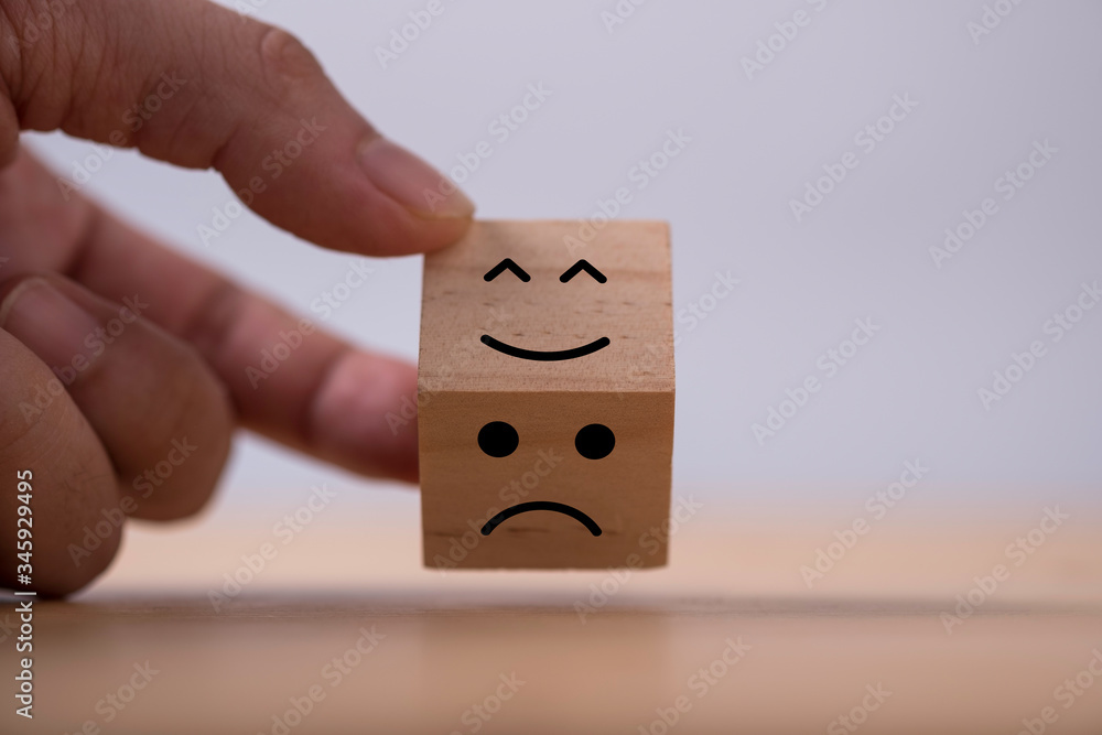 Poster hand flipping change emotions from sad to happy which print screen on wooden cubic. customer experie