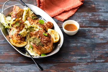 Grilled turkey steak with cabbage and herbs on a wooden background.