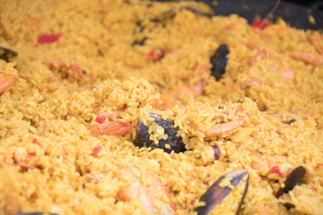 Seafood paella cooked in a large pan wok, street food festival. Mexican fiesta