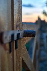 wooden gate with a rustic wooden staple closure covered with rain drops