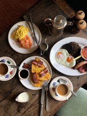 Traditional rustic English breakfast served on the wooden table with coffee and tea