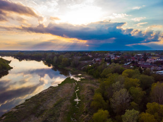 Shot from a drone at sunset with clouds, which is reflected in the river