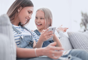 close up.happy mom and her daughter are watching videos on smartphone