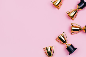 Winner cups on a pink background. Banner with a place for text. Flat lay style.