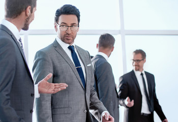 businessman talking with boss in industrial interior