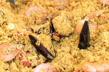 Seafood paella cooked in a large pan wok, street food festival. Mexican fiesta