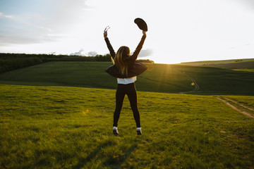 Fototapeta na wymiar Girl jumping up with joy at sunset
