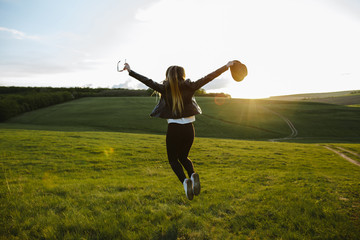Girl jumping up with joy at sunset