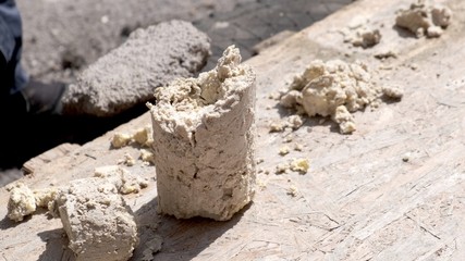 A large piece of compressed grease and dirt, which was removed from the sewer. Close-up.