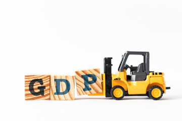 Toy forklift hold wood letter block P to complete word GDP (Gross domestic product or Good distribution practice) on white background