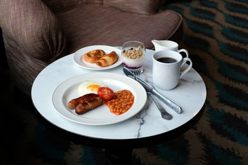 Full English breakfast served with coffee and fresh pastries in a hotel