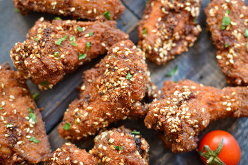 Baked chicken wings with sesame seeds. Ketchup and chili sauce. Close up. Top view. Delicious fried chicken wings.