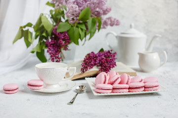 A Cup of morning coffee, a bowl of lilac, macaroni, on a light background. Postcard good morning