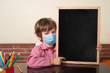 School boy in class shows empty blackboard