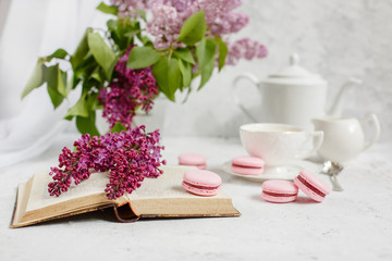 A Cup of morning coffee, a bowl of lilac, macaroni, on a light background. Postcard good morning